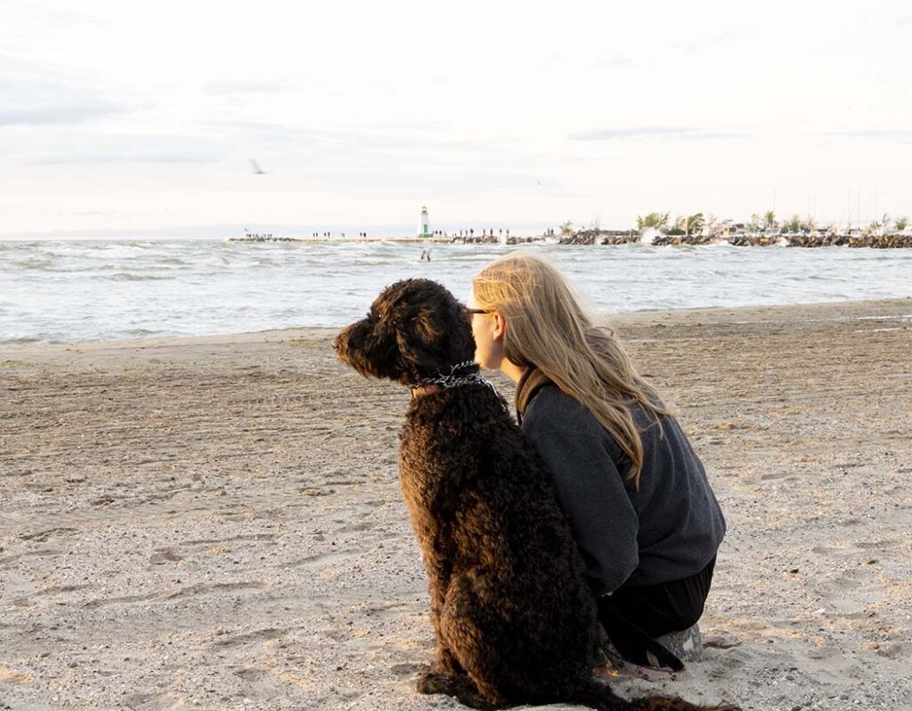 Showing a large aperture of a girl and a dog at the beach.