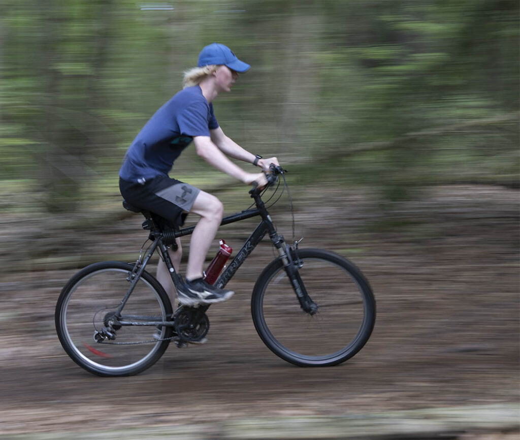 Boy on a bike showing the background moving-showing a slower shutter speed.