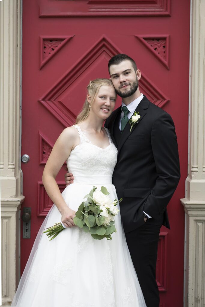 Wedding portrait, standing in front of a red door.